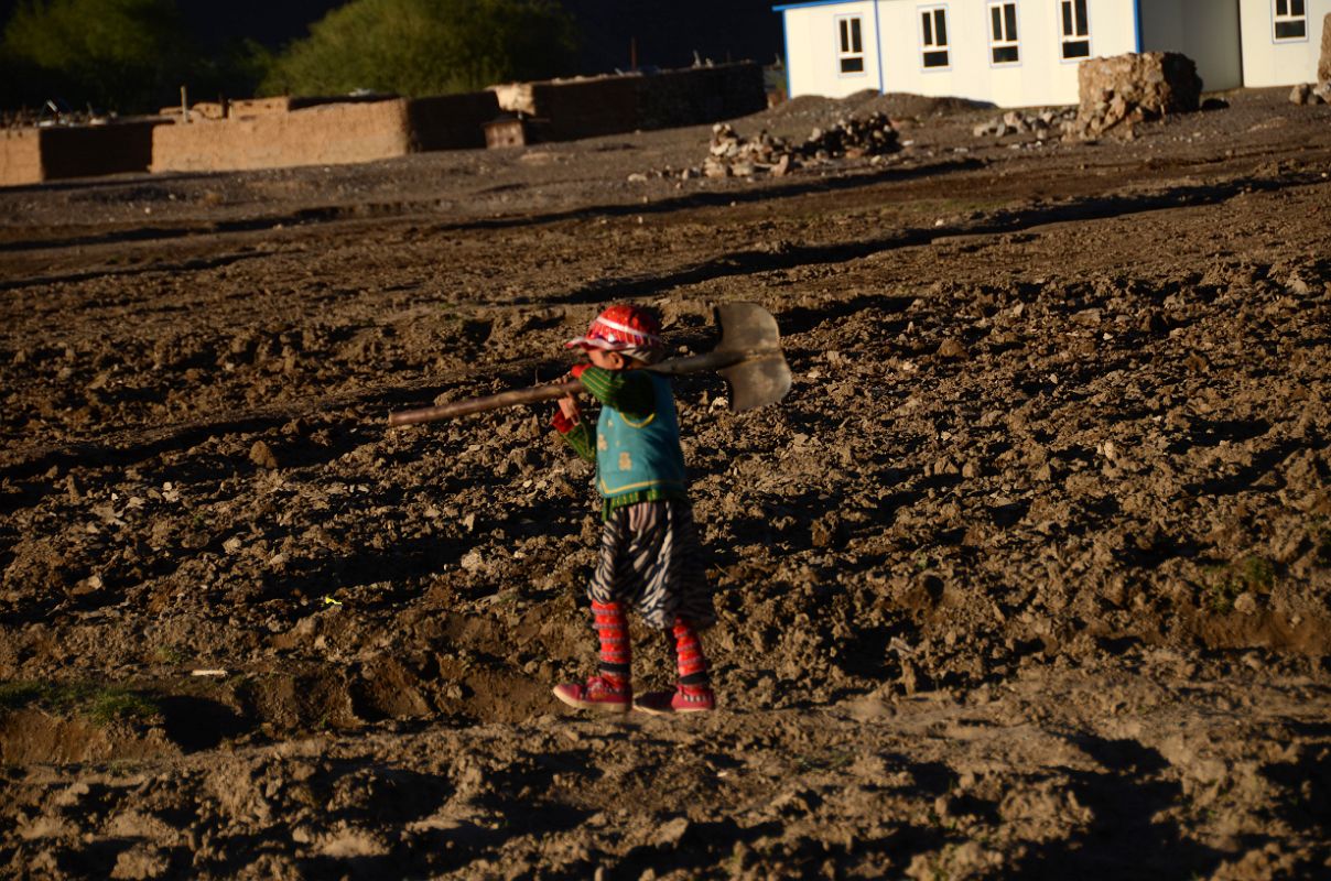 14 Child In Colourful Clothing Carrying Shovel Through The Tilled Fields At Sunset In Yilik Village On The Way To K2 China Trek